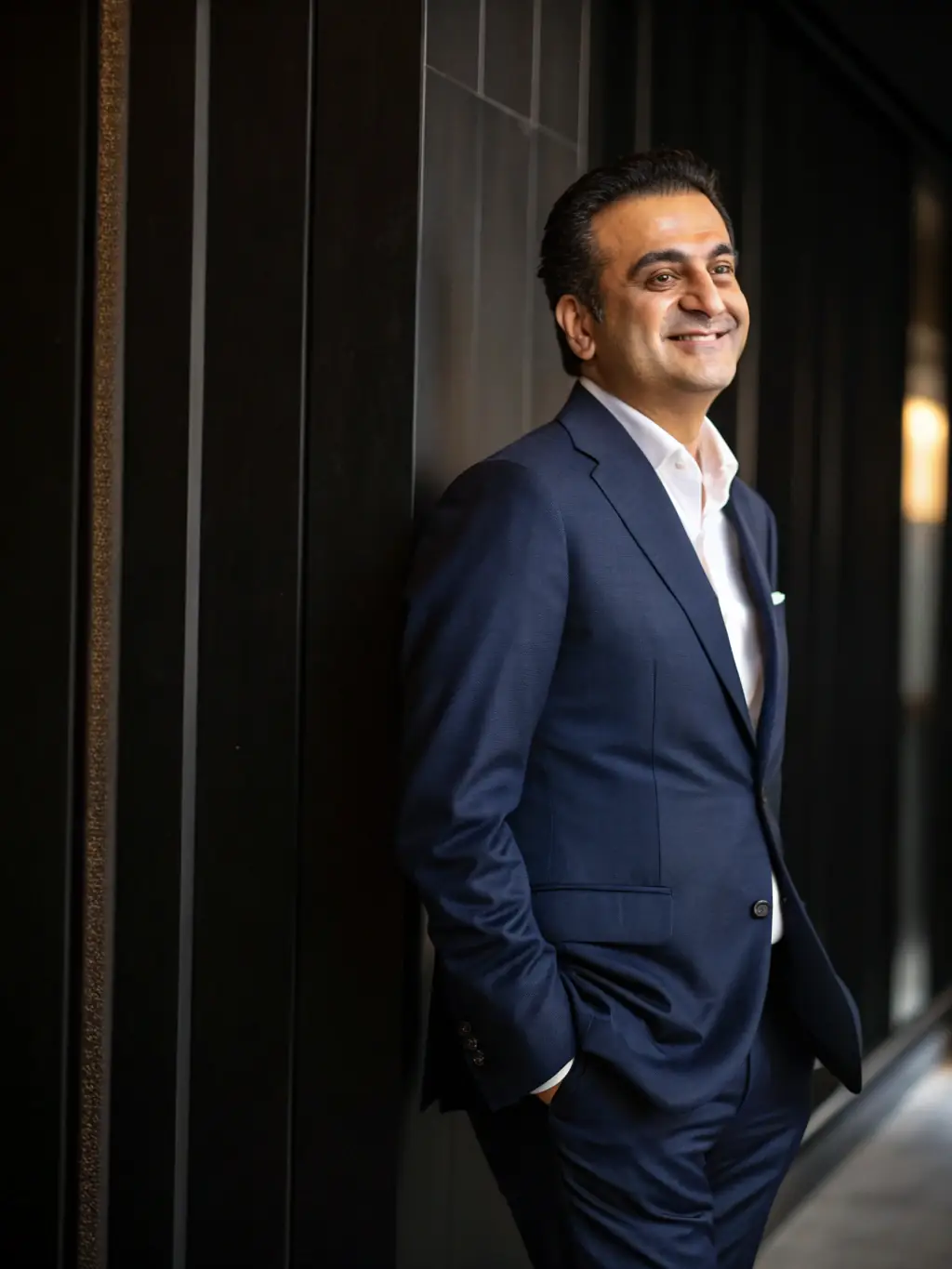 A professional headshot of Mohammad Amid in a modern Dubai office, smiling confidently and looking directly at the camera, symbolizing trust and expertise.